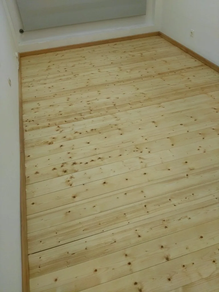 Frisch geschliffene helle Nadelholzdielen im Zimmer
