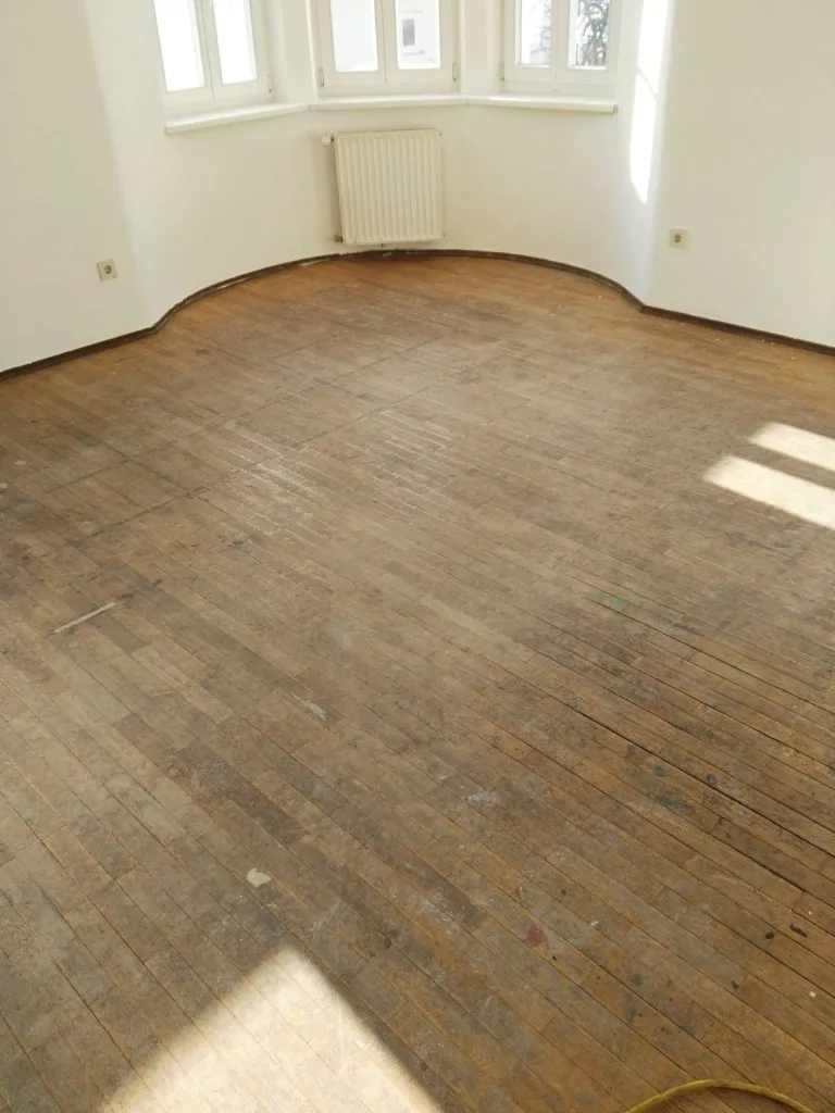 Abgenutztes Parkett im Wohnzimmer mit Erker vor dem Schliff