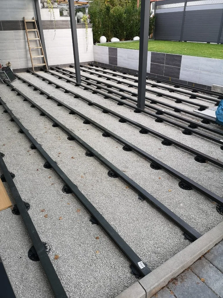 Terrassen-Unterkonstruktion auf Stelzlagern mit Aluminiumschienen über Kiesbett